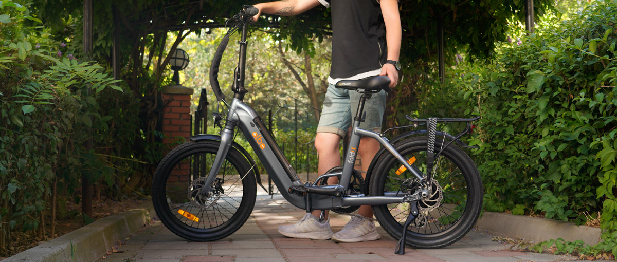 Man holding Alba fold X electric bike in park