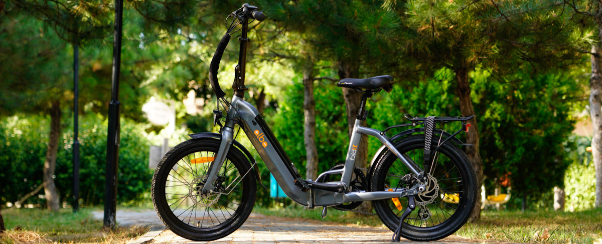 Alba Fold X Electric bike in dark grey colour on a woodland trail