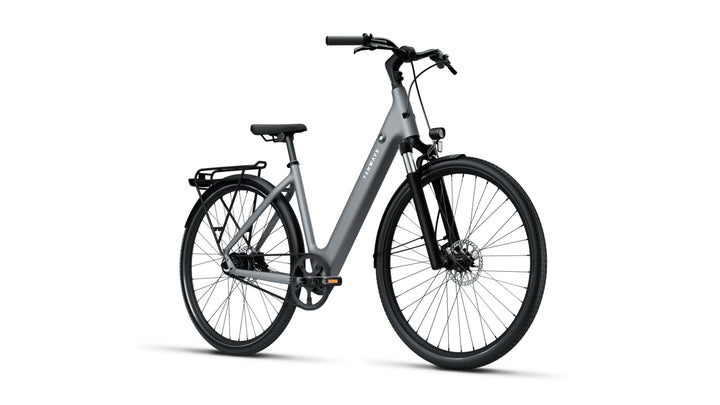 Front-right profile of Tenways 800S electric bike in Pebble Grey with a step-through frame, integrated battery, belt drive system, front suspension fork, and rear rack.